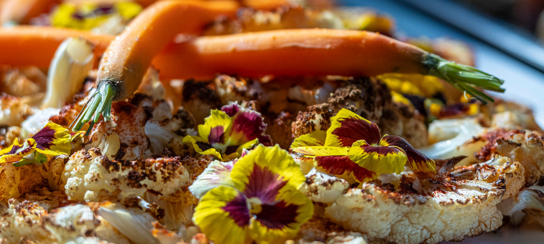 Geröstete Blumenkohl-Platte mit Karotten und essbaren Blüten